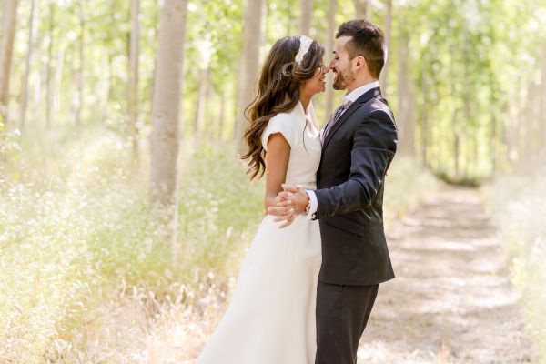 An image of a bride and groom kissing in field